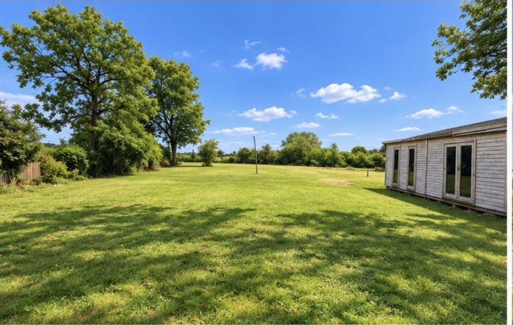 Large grassy paddock beside the pub with a cabin, space for motorhomes and tourers