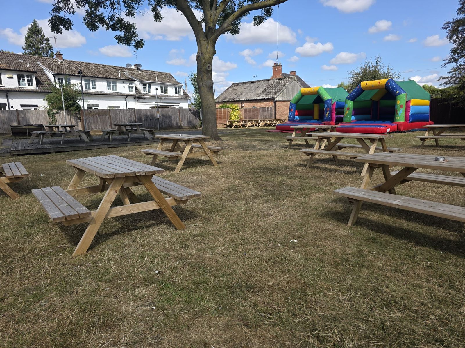 Picnic benches under a large tree in the beer garden